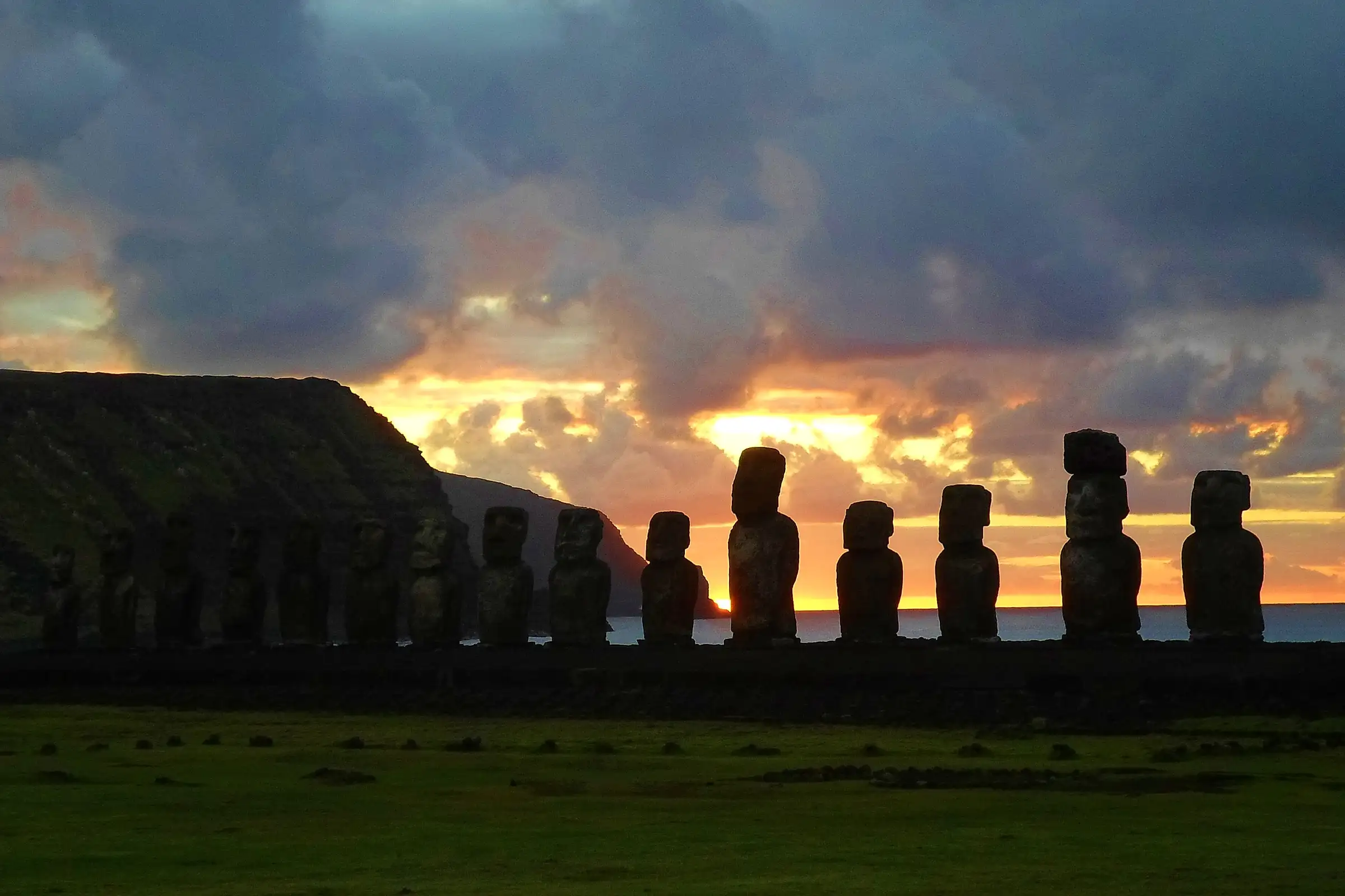 The fifteen moai of Ahu Tongariki in silhouette against an orange sunrise, Easter Island, Chile