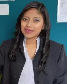 Tatiana Ayala smiling at her desk with a laptop