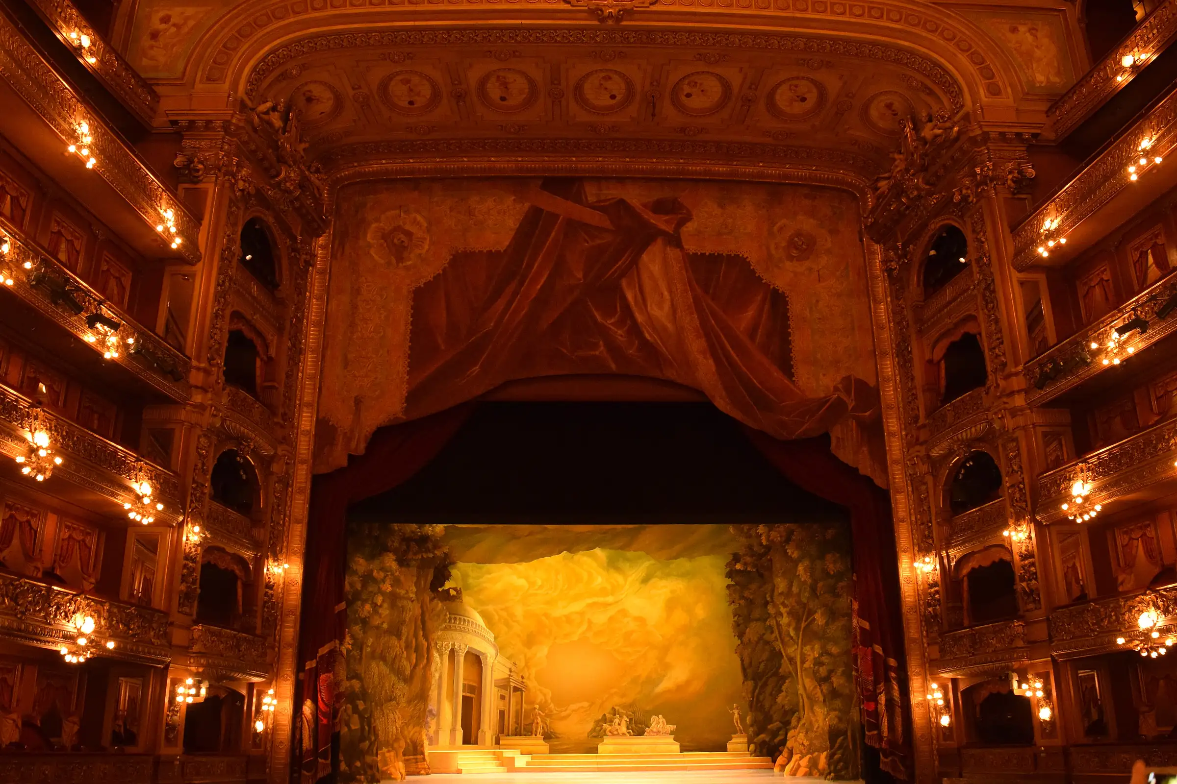 The main hall of the Teatro Colón in Buenos Aires, with gilded boxes on every tier around the lit stage