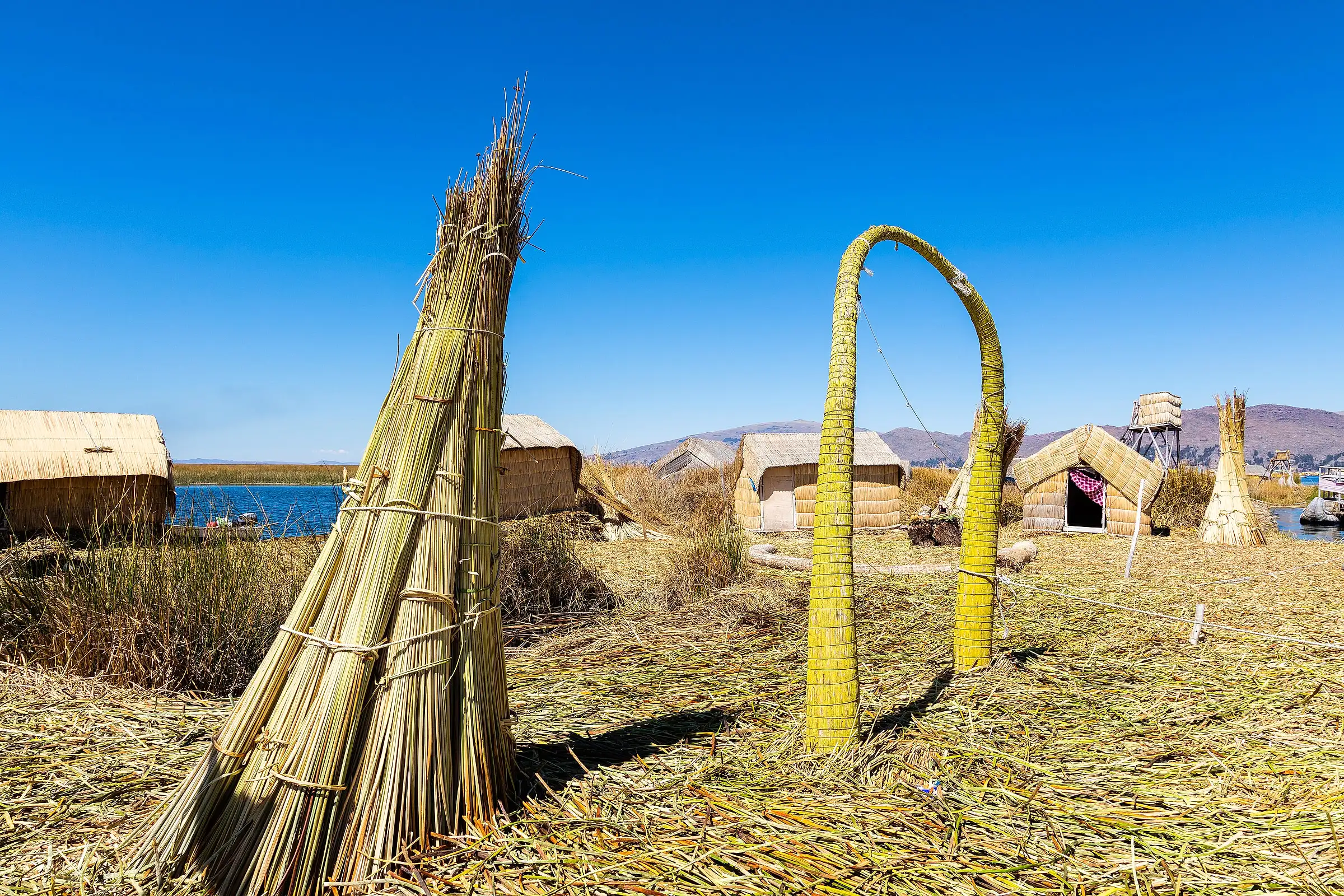 Reed houses and totora boats on one of the Uros floating islands on Lake Titicaca, Peru