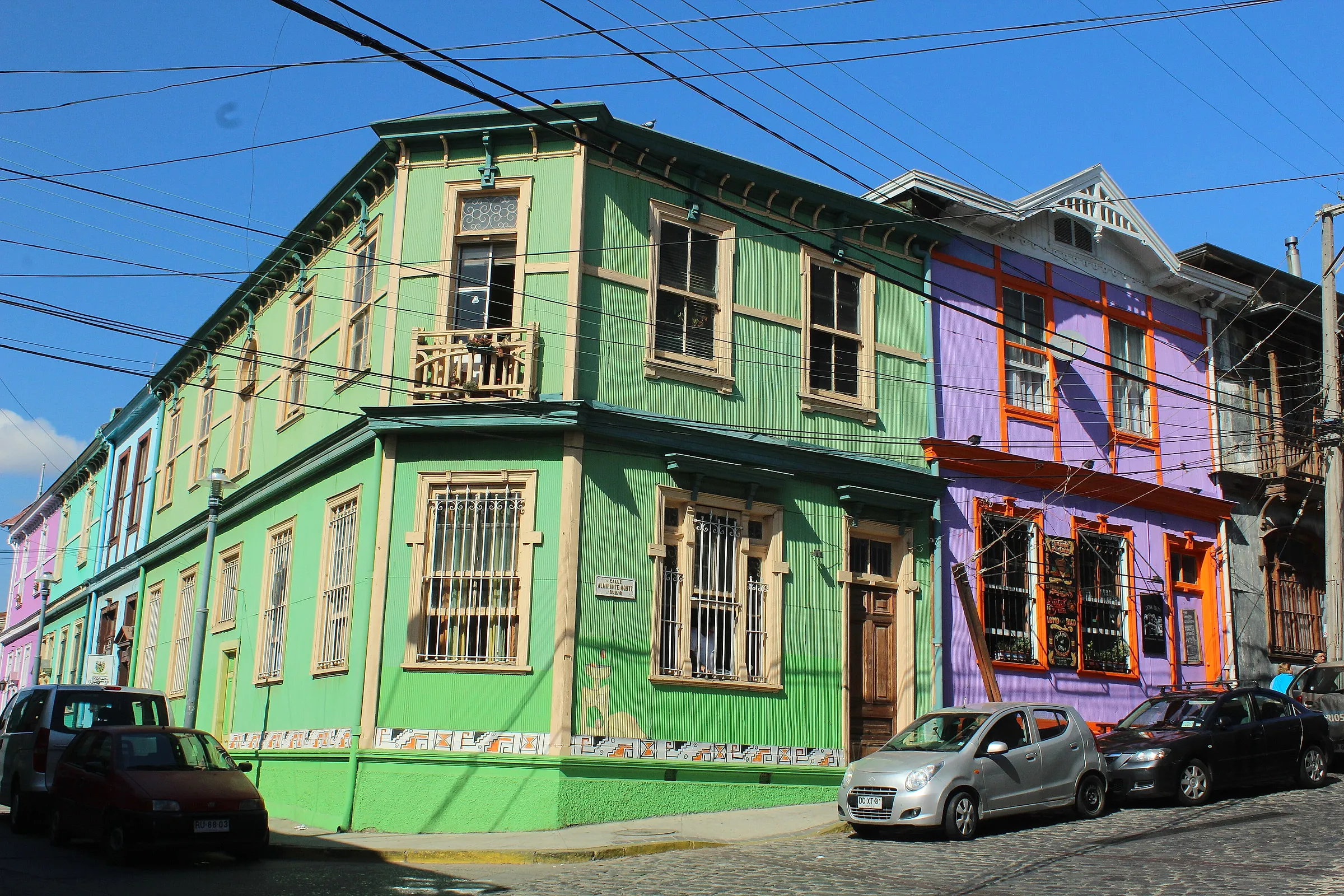 Painted wooden houses in green and violet on a cobbled street on one of Valparaíso’s hills, Chile